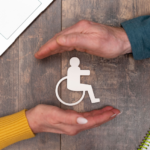 A couple's hands are safeguarding disability logo on a table.